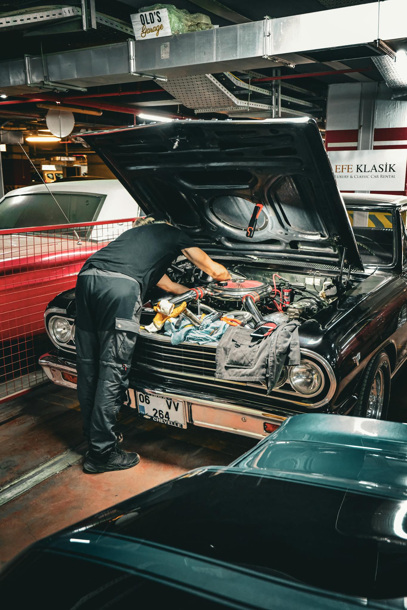 Mechanic repairing classic car engine in an Ankara garage, capturing vintage automotive repair scene.